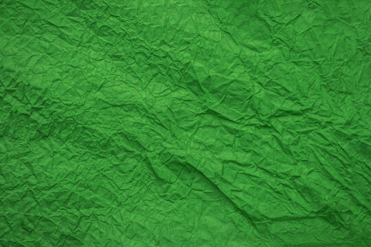 Background from crumpled green paper top view. Crumpled paper texture. Free space for text and advertising