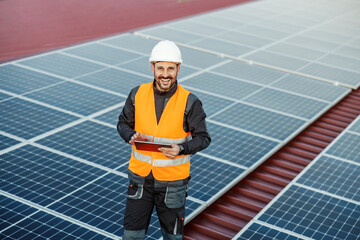 Portrait of a supervisor testing solar panels on a tablet.