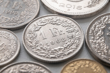 Swiss franc coins on white surface. Value of the Swiss Franc and exchange rate trend.
