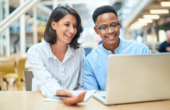 Its up to both of us to bring the results. Shot of a young businessman and businesswoman using a laptop in a modern office.
