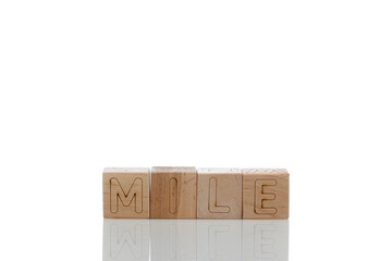 Wooden cubes with letters mile on a white background