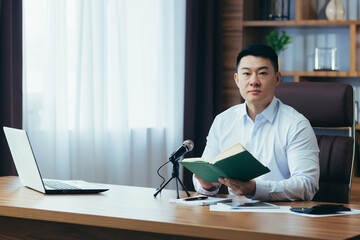 Asian freelancer records audio podcasts, businessman works in office, uses professional microphone...
