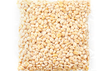 Pine nuts in a transparent vacuum package over