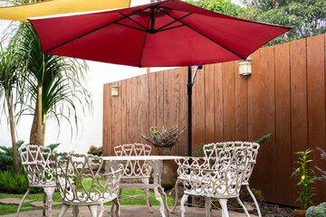 Plakat Wooden deck with stone floor in the backyard. Patio with chairs and umbrella for outdoor seating and dining with