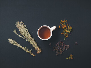 White cup of tea with herbs on a gray background flat lay still life