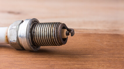 used worn spark plug in shallow depth of field on a table top, closeup macro with copy space