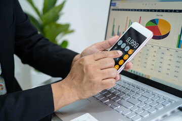 Asian accountant working and analyzing financial reports project accounting with chart graph and calculator in modern office, finance and business concept.