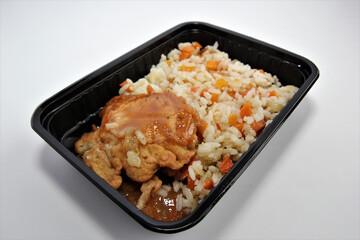 Pollack fried in batter with rice in a plastic container. Lunch in a disposable dish.