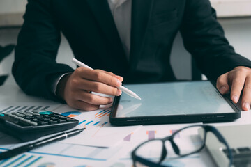 Closeup businessman hand using tablet computer at work