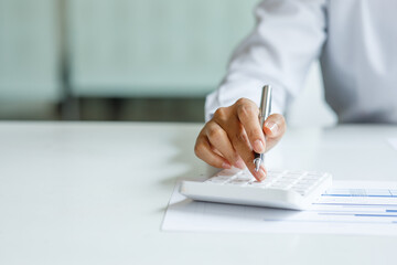 Close up of businesswoman Accounting using calculating income-expenditure and analyzing real estate...