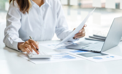 Close up of businesswoman Accounting using calculating income-expenditure and analyzing real estate...