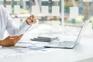 Close up of businesswoman Accounting using calculating income-expenditure and analyzing real estate...