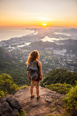 Beautiful sunset view to woman on rocky rainforest mountain - obrazy, fototapety, plakaty
