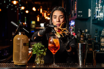 Latin brunette waitress prepares a cocktail at the bar. profession