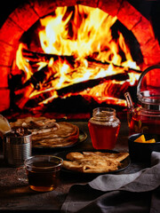 homemade pancakes in a black plate, tea on the background of a b