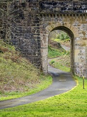 Fototapeta na wymiar Pathway through the stone archway at Culzean castle in springtime