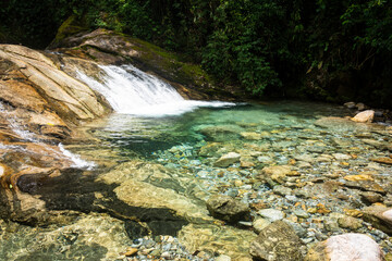 Naklejka na ściany i meble Beautiful view to green atlantic rainforest waterfall with blue water