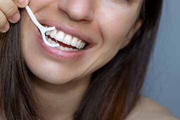 young woman using dental floss, toothpick. girl is holding with teeth a white toothpick. dental...