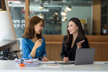Two Asian businesswoman sitting discuss investment project working and business planning strategy at office.