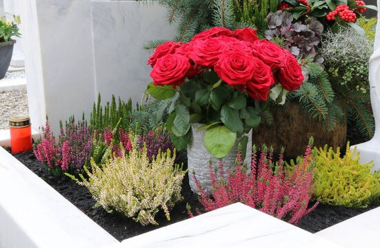 Grabgestaltung an einem katholischen Friedhof in Österreich, Blumenschmuck mit Rosenstrauß und Erika an einem Familiengrab