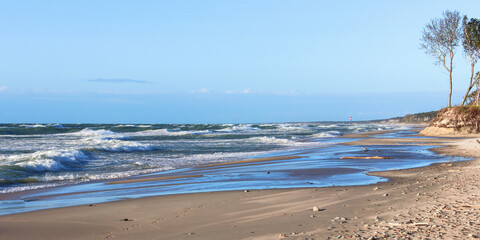 wide beach waves on the sea on a clear sunny day