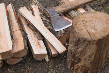 Close-up of a stack of chopped cut wood and an axe