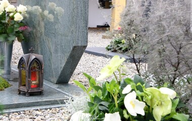 Grabgestaltung an einem katholischen Friedhof in Österreich mit Grablaterne, weißen Rosen und Schneerosen, Allerheiligen, Tod, Gedenken, Trauer
