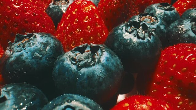 Macro shot of fresh blueberries and strawberries composition.
