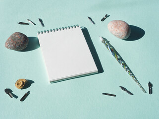 Mock up of white notebook for sketch, artwork or calligraphy on blue background. Turquoise desk...