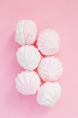 Delicate white marshmallows on a pink background. Creative design of sweets