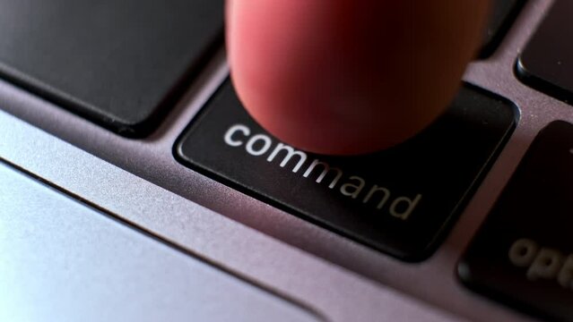 Person presses command key on powerful laptop keyboard extreme close view. User tries to input data by computer. Technology issues