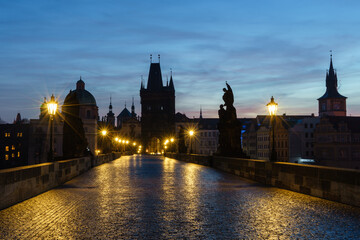 Beleuchtete Karlsbrücke in Prag, Tschechien, in der Morgendämmerung; Karlsbrücke früh am Morgen