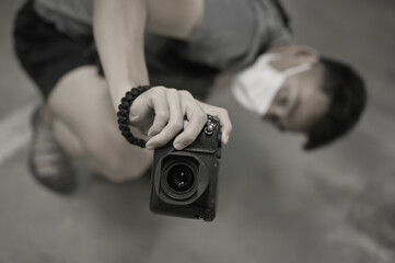 High angle view, top view point and selective focus of young man photographer using a camera