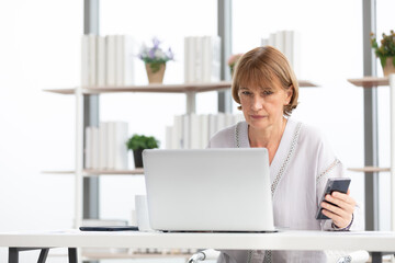 senior businesswoman or freelancer looking smartphone for checking something for work