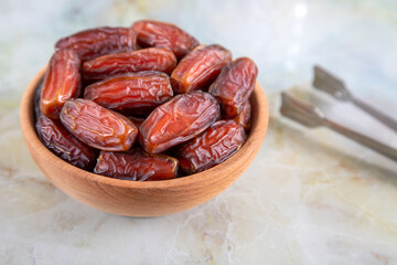 Bowl of dates fruit on colorful marble background, top view