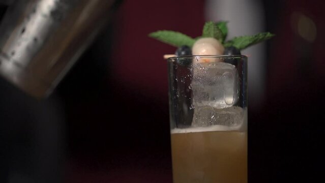 Bartender serving a fruit cocktail with ice