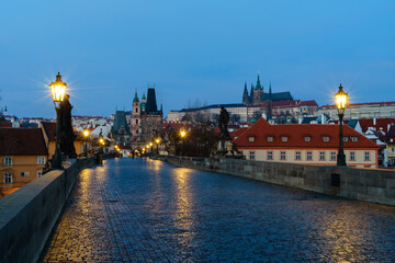 Karlsbrücke in Prag, Tschechien, mit der Prager Burg im Hintergrund in der Morgendämmerung;...