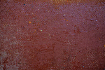 Scratches, sand, cracks abstract texture background. An old shabby red surface with lots of scratches, sand, dust and peeling paint.