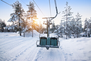 Ski lift at sunrise in the beautiful snowy nature at mountain Ounasvaara, Rovaniemi. Popular winter...