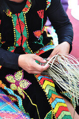 Hands of woman showing weaving action of traditional bamboo basket from the Kadazan Dusun Murut...