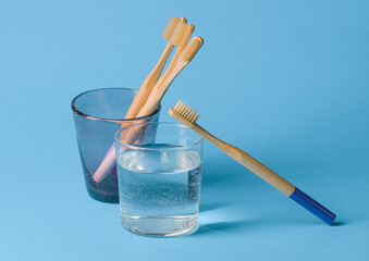 wooden toothbrushes in a glass on a blue background