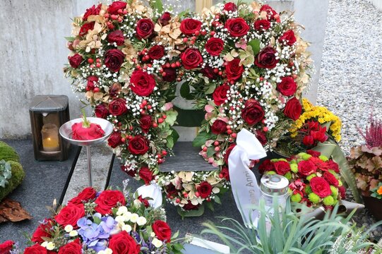 Grabschmuck an einem katholischen Friedhof in Österreich zu Allerheiligen, ein Herz aus Rosen und anderen gemischten Blumen, Bestattung, Trauer, Floristik, Totengedenken