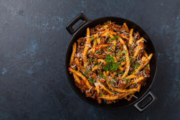 Maccheroni al ferretto with beef in ragu bolognese. Top view.