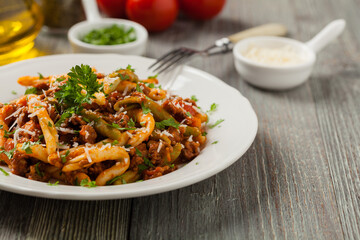 Maccheroni al ferretto with beef in ragu bolognese. Front view.