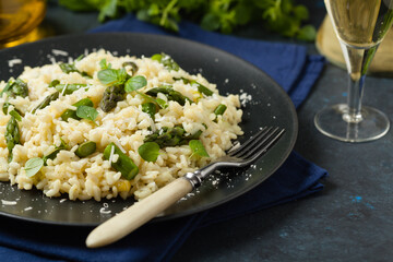 Classic Italian risotto with asparagus. Front view. Darkblue background.