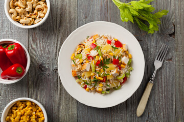 Salad with rice, chicken, peanuts and vegetables. Top view.