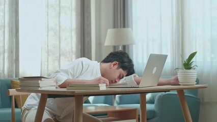 Asian Man Student Sleeping While Using Computer To Study Online At Home

