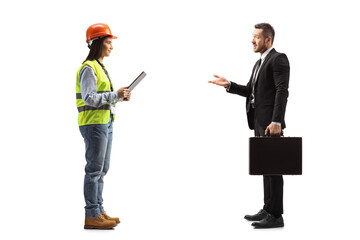 Businessman with a briefcase talking to a young female site engineer