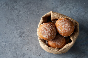 Top view Berliners in a burlap basket on gray base