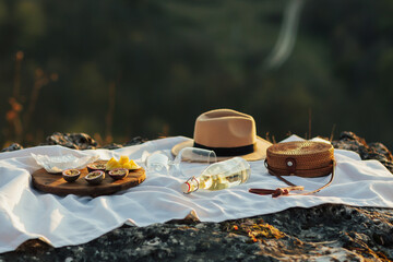 Cozy picnic with a delicious fresh tropical fruits, cheese brie and wine on the white tablecloth at...